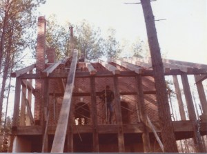Rafter raising day. The tall pole sticking up above the brick wall is the gin pole. There's a pulley on top: a rope went over the pulley and to a tractor on the other side to pull the rafters up.