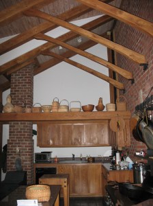 A pegged mortise and tenon joins the brace to the rafter.  The brace butts against the brick wall.  There's a lag screw through the bracket into the brace.